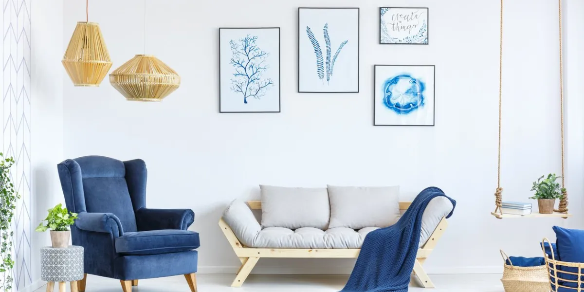 white and blue living room with sofa, armchair, lamp, posters