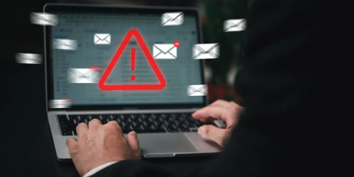 man using laptop computer with hacker alarm protecting data from cybercrime in the digital age internet security and privacy defending against data theft and email breach