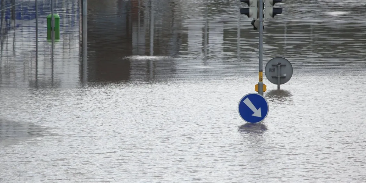 flooded crossroad with traffic lights and a keep right traffic sign partially flooded by the swollen vltava river in prague, czech republic