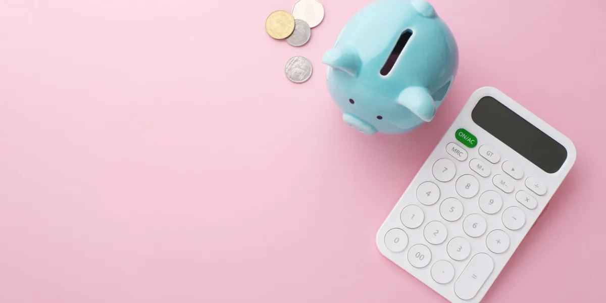 piggy bank, calculator and coin on pink background, saving money concept, flat lay