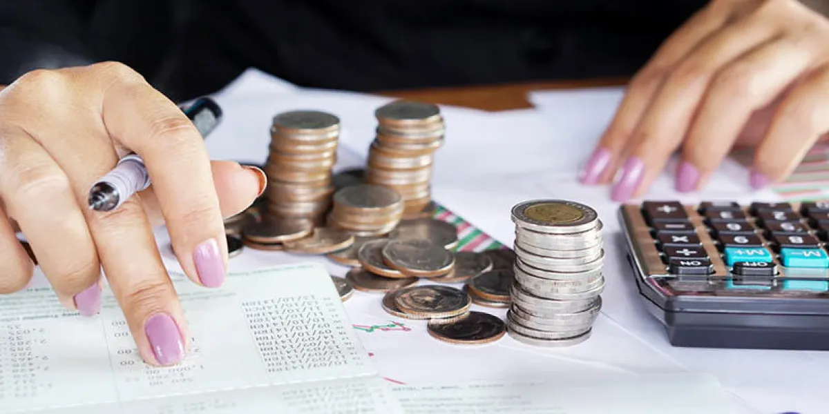 businesswoman hand counting on saving account with stack of coins, credit card and calculator