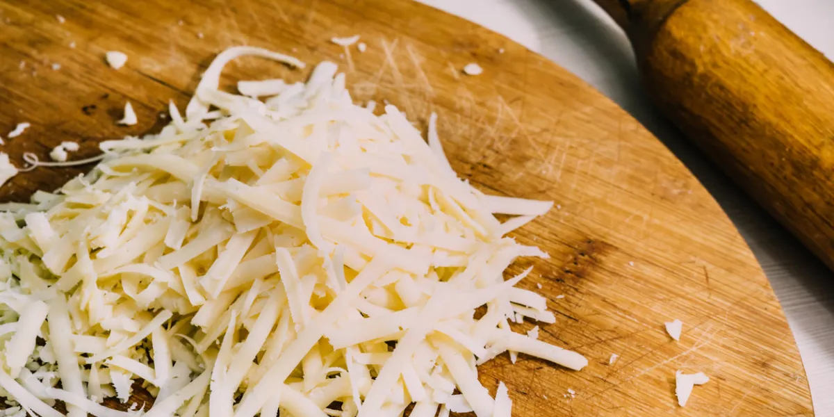 three different kinds of shredded cheese on a wooden board the concept of cooking macro food photo close up
