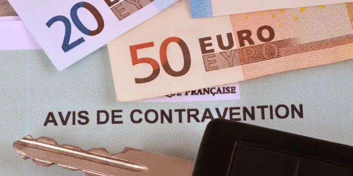 notice of contravention with a car key and banknotes