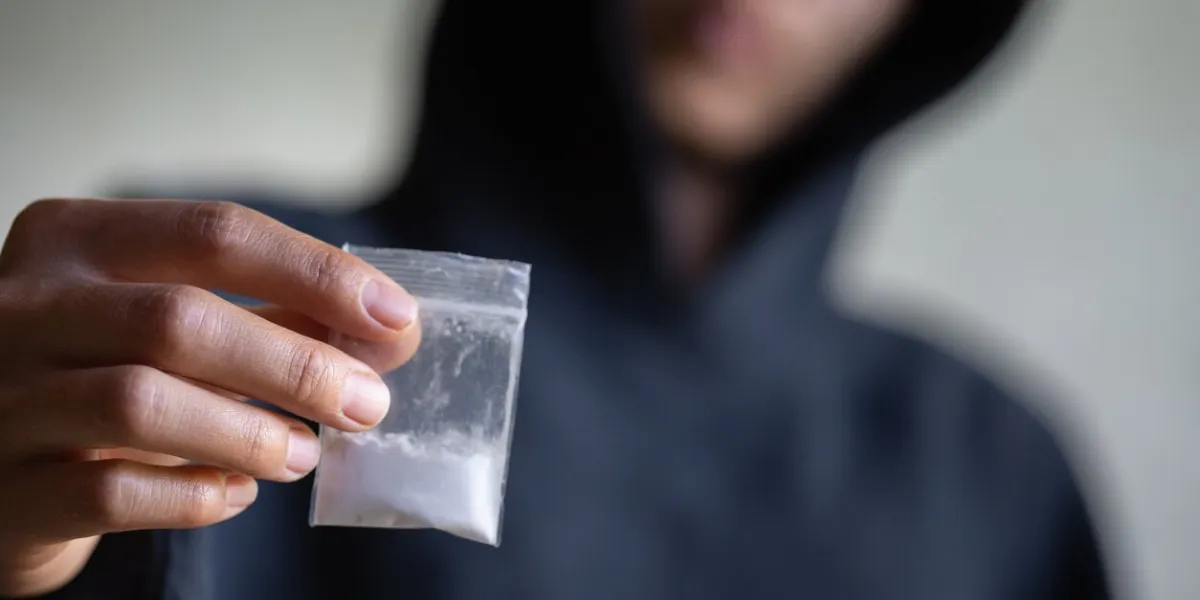 hand of addict man holding cocaine or heroine, close up of addict buying dose from drug dealer, drug trafficking, crime, addiction and sale concept