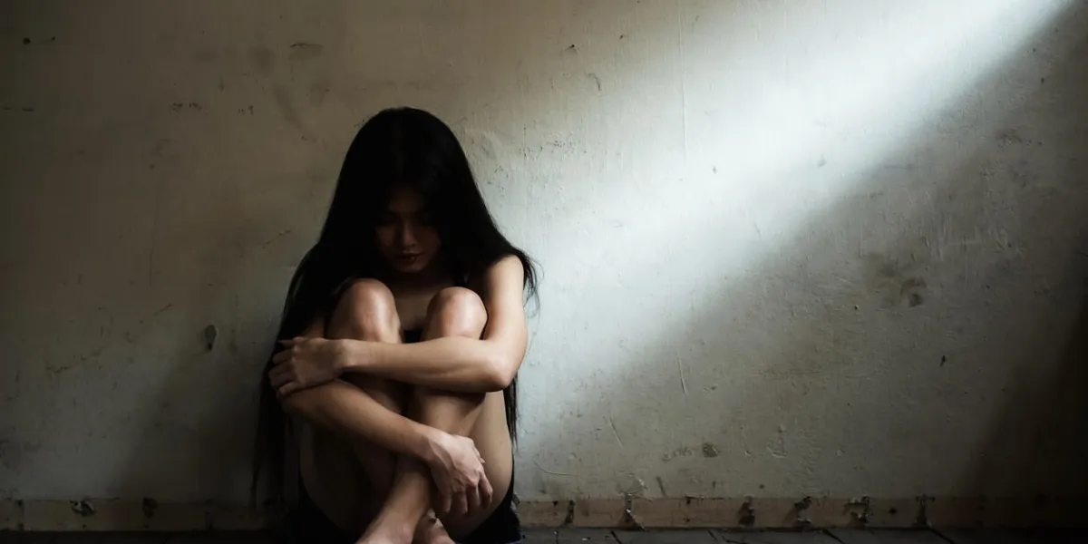 depressed woman sitting on bare floor