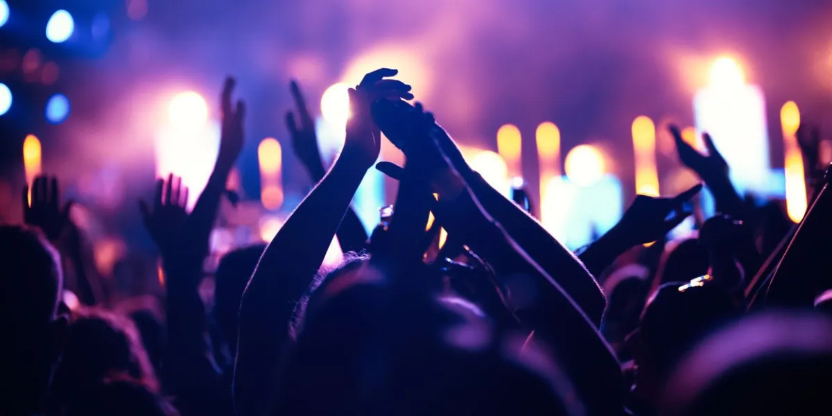 happy cheering crowd with hands in air at music festival