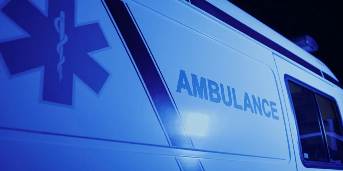 closeup emergency body of car with logo detailed view of ambulance vehicle with emblem medical symbols on first aid van red and blue lights flashing on car at night on street first aid concept