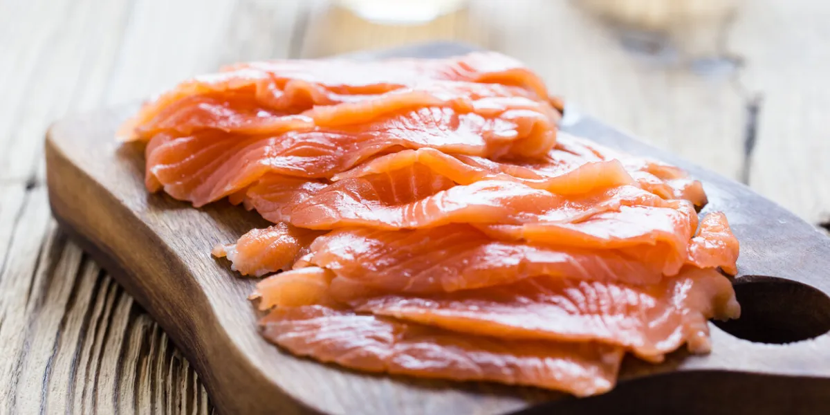 homemade smoked salmon on wooden board, sliced, close up, selective focus