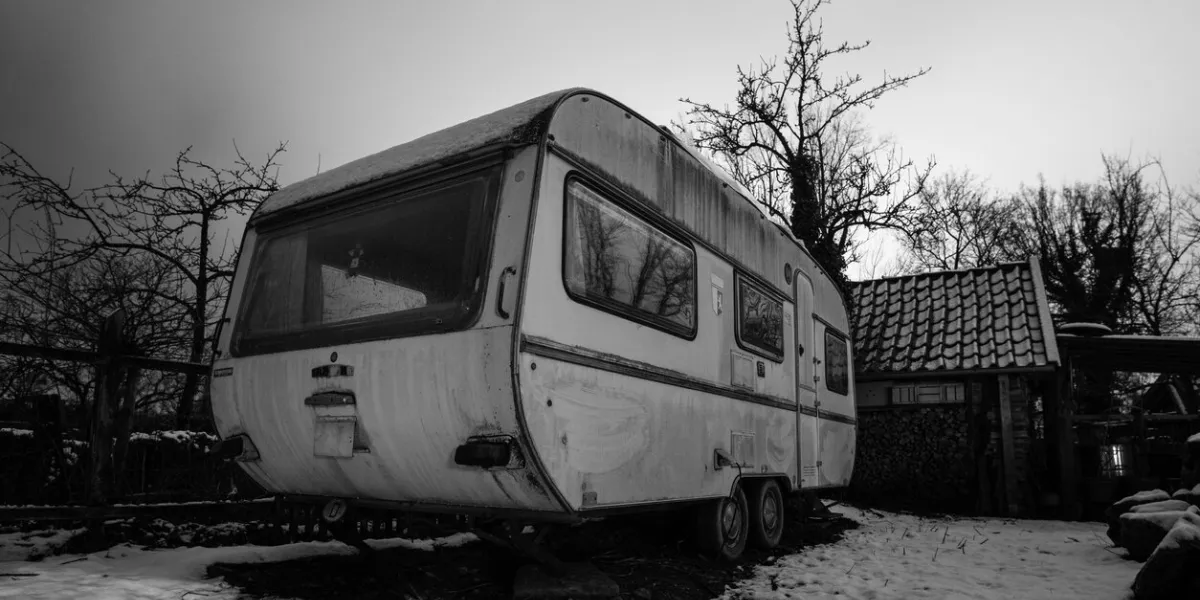 old camping trailer standing at a farm at night in winter, germany