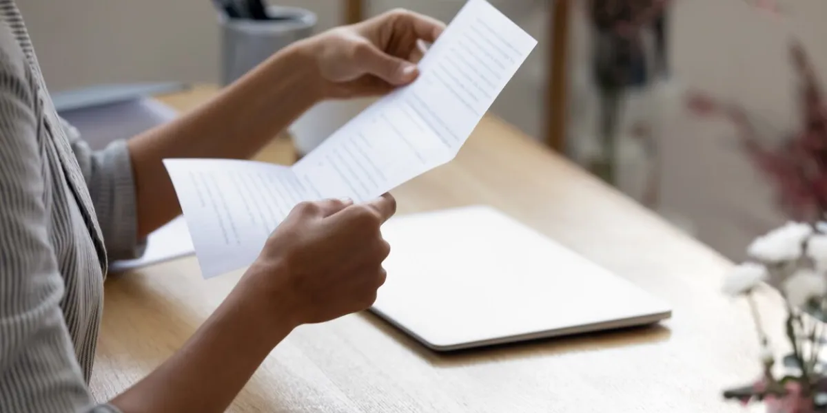 close up young woman holding paper letter with good news, getting banking loan approval millennial businesswoman received correspondence, reading fashion show or special event invitation indoors