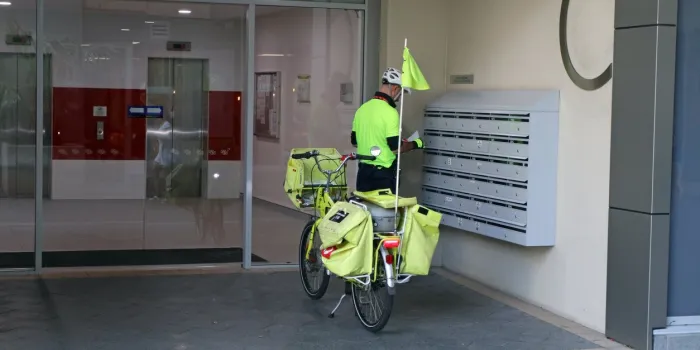 sydney, australia - january 29, 2019  postman in his work distributing mail in the center of the city in sydney