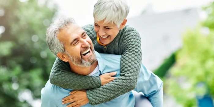 woman man outdoor senior couple happy lifestyle retirement together smiling love piggyback active mature