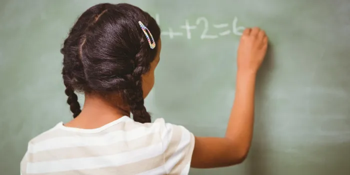 arrière, vue, de, petite fille, écriture, sur, tableau noir, dans, les, classe