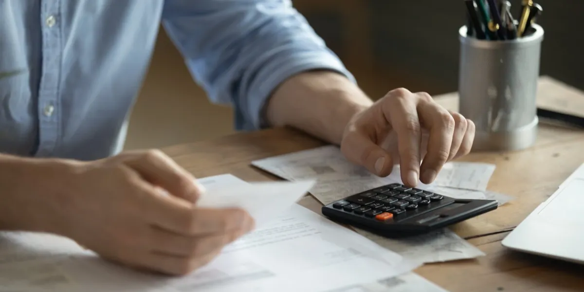 personal finance management, accounting concept close up view man sitting at table using calculator performs arithmetic operations calculates costs per month, manage family budget, control expenses