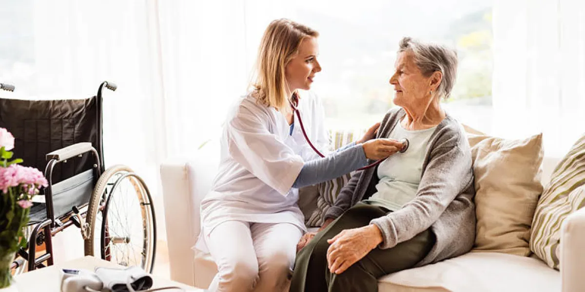 health visitor and a senior woman during home visit a nurse or a doctor examining a woman