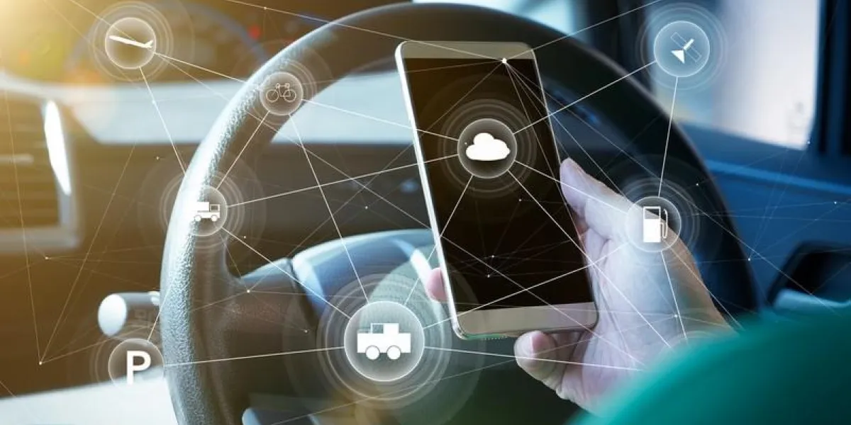 man driver using smart self-driving car control system on a hand phone futuristic driving technology concept