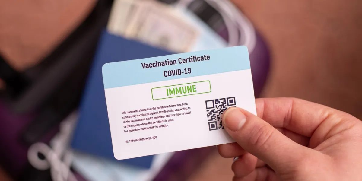 covid-19 vaccination certificate in hand of a immune person