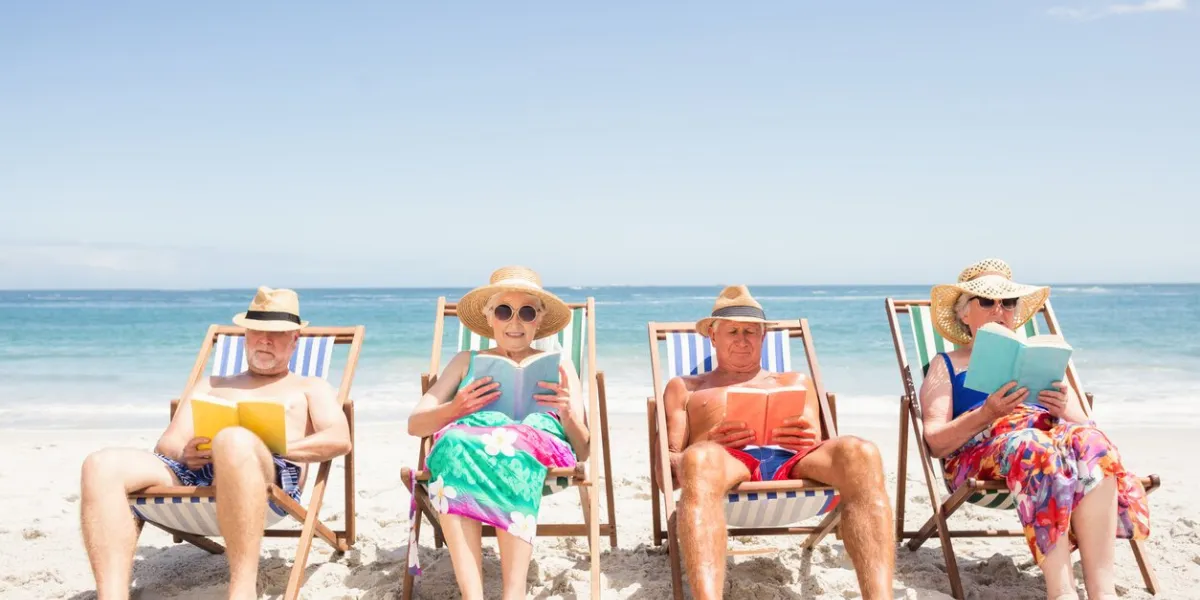 senior friends reading books on beach chair at the beach