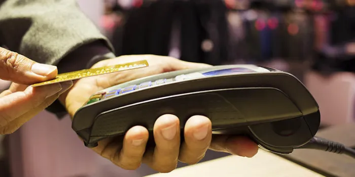 man paying with nfc technology on credit card, in clothing store