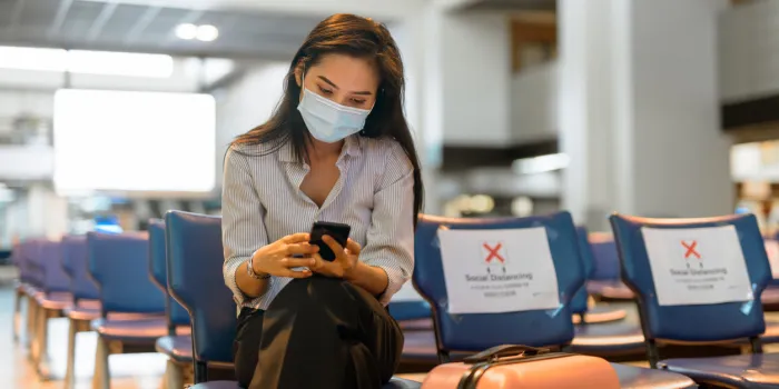portrait of young asian tourist woman with mask for protection from corona virus outbreak social distancing at the airport