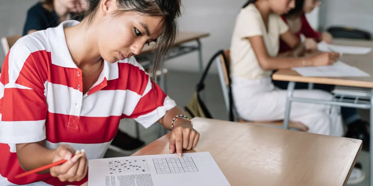 female asian student writing exam exercise in the college high school classroom