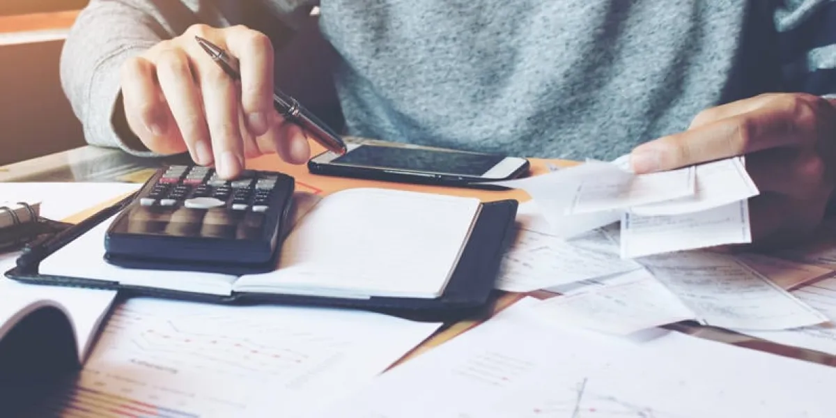 homme à l'aide de la calculatrice et calculer les factures dans le bureau à domicile