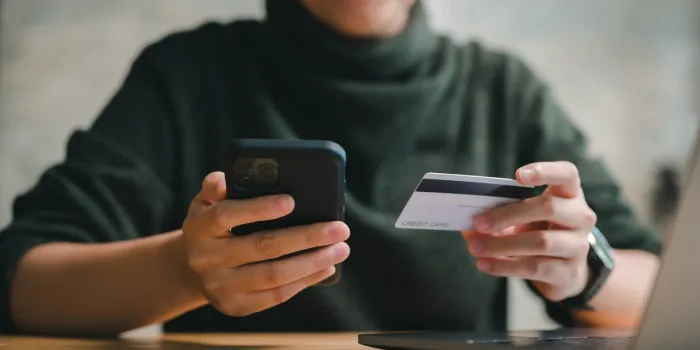 online shopping and e-commerce concept, happy smile woman hand using smartphone and holding credit card for shopping payment online at home