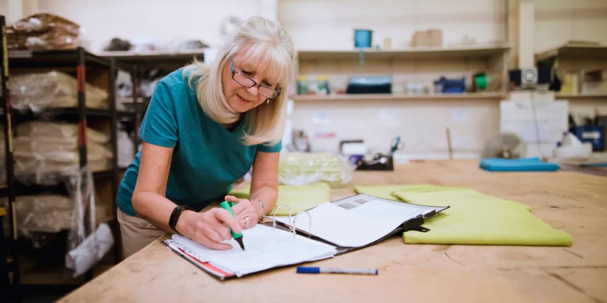 senior businesswoman is doing paperwork in her stock factory