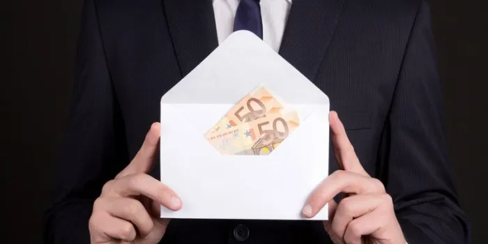 white envelope with money in business man hands