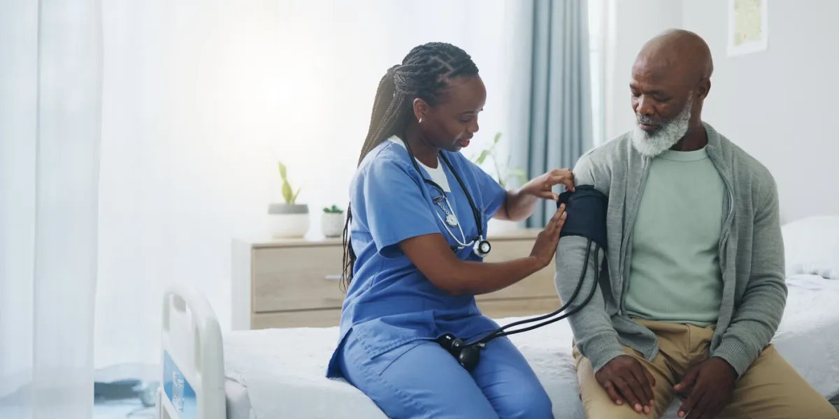 healthcare, senior man and nurse with monitor for blood pressure, medical test and cardiovascular hospital bed, mature patient and caregiver for hypertension diagnosis, examine or consultation