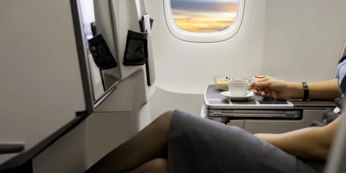 cup of fresh espresso on table in airplane interior