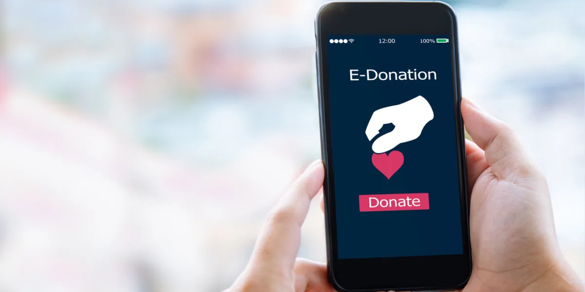 close-up of man hands make an online donate via mobile phone