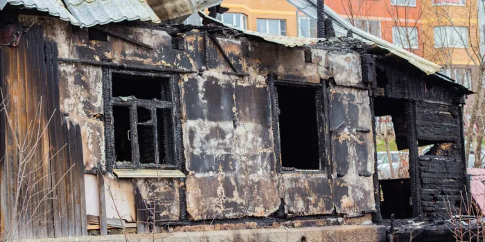 the charred wall of the house, the arson close-up the destruction of a village house on the outskirts of the city the city crowds out the village