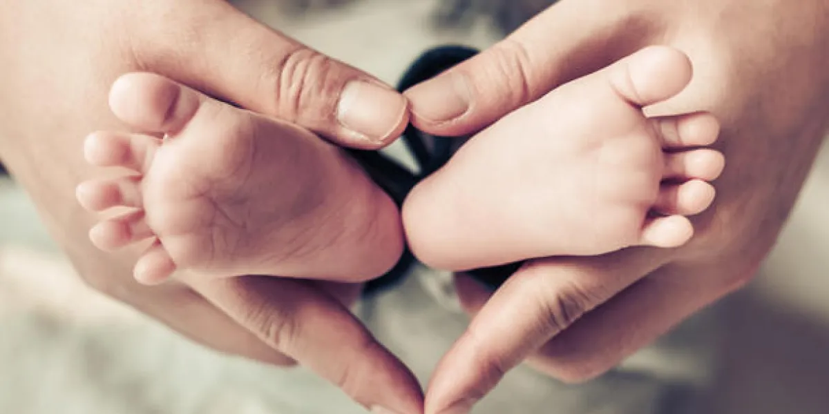 pieds de bébé nouveau-né sur les mains féminines