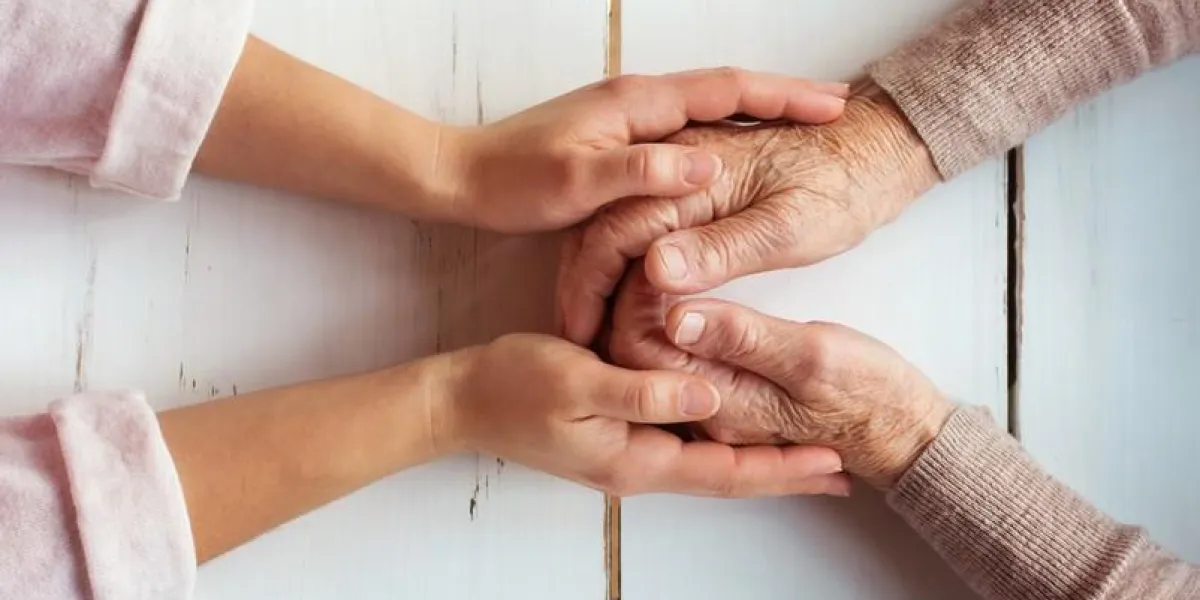 unrecognizable grandmother and her granddaughter holding hands