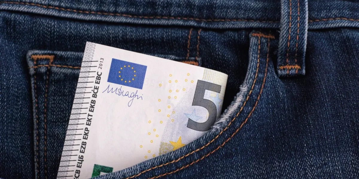 five euro banknote in a pocket of blue jeans close up