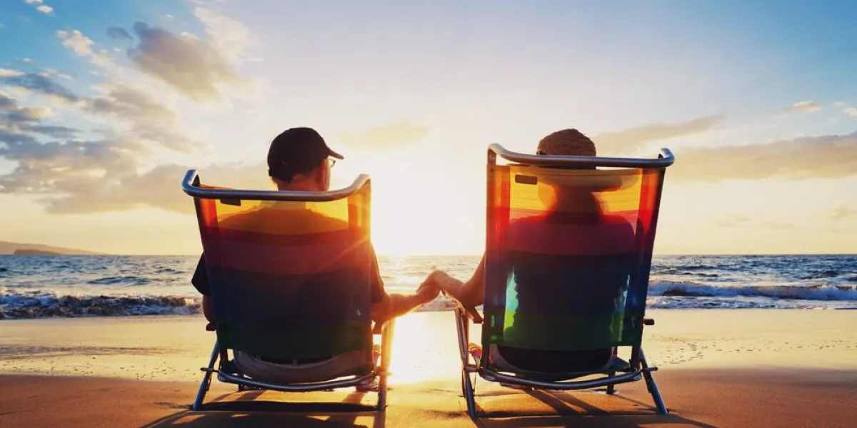 senior couple de vieil homme et une femme assise sur la plage, regarder le coucher du soleil