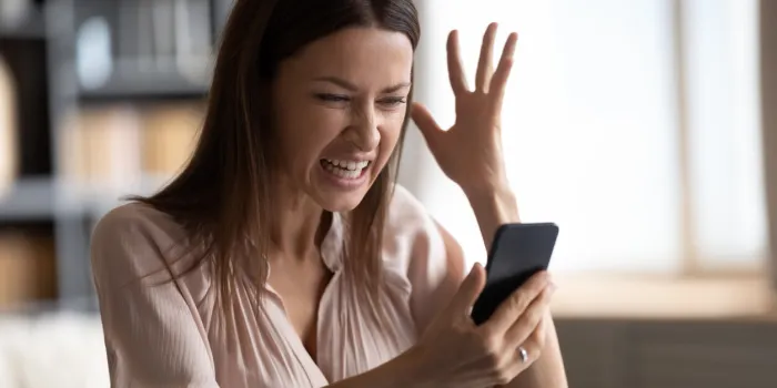 mad young woman look at smartphone screen have operational gadget problems, angry millennial female feel stressed frustrated with slow internet connection, bad service on modern cellphone device