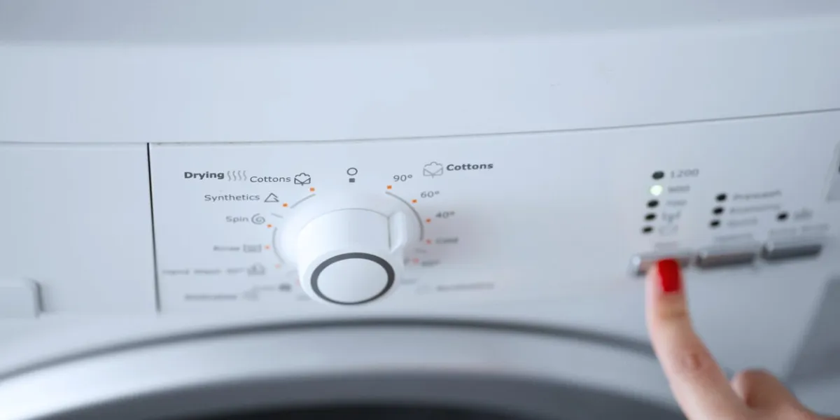 the girl sets the washing program for the washing machine