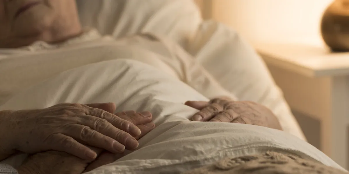 close-up of hand of senior on hand of dying elderly person as sign of support during sickness