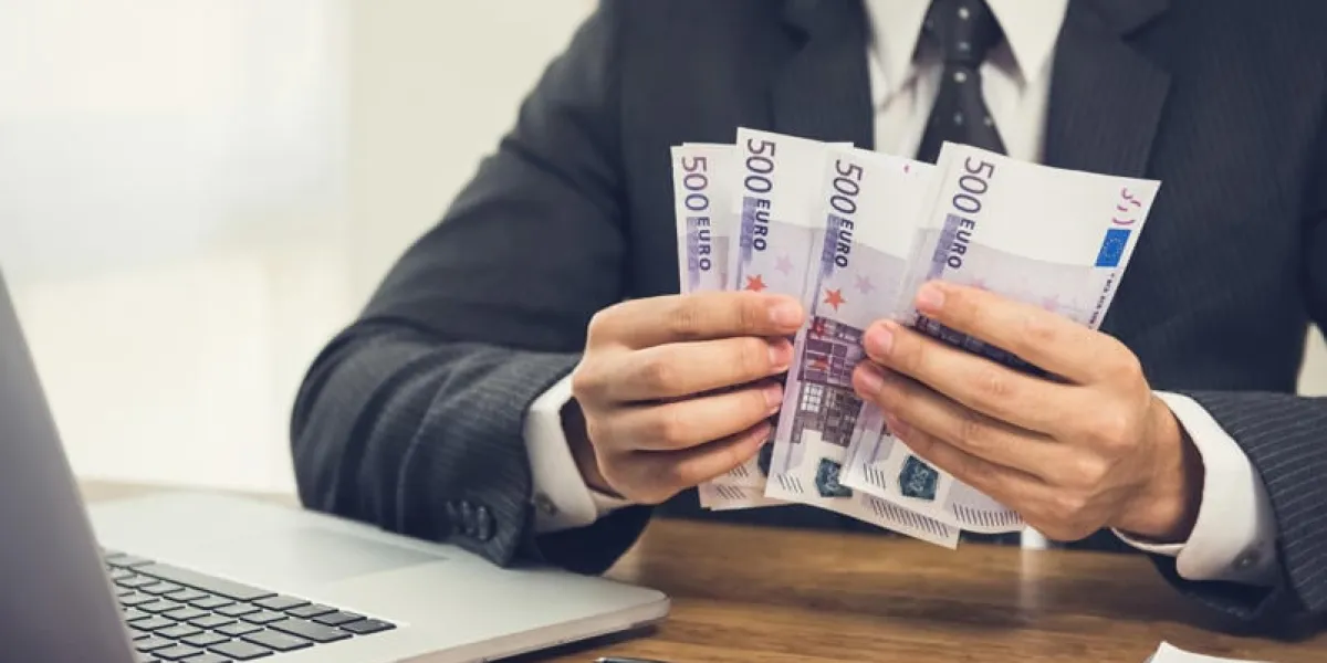 businessman counting money, euro banknotes, at his working desk - financial and investment concepts