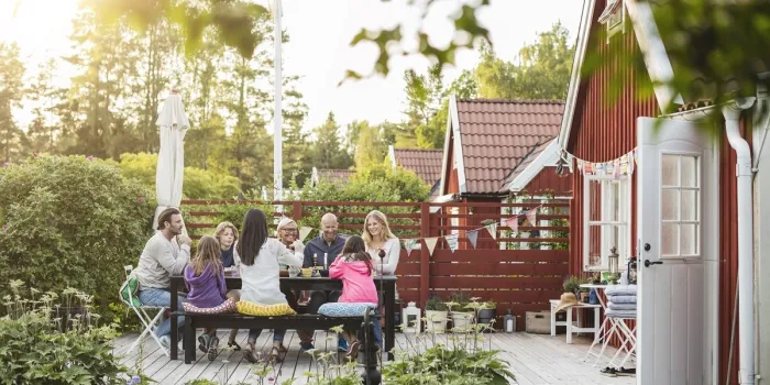 happy family and friends eating at garden lunch party in back yard