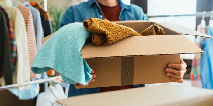 man holding box with clothes, concept of clothes donation