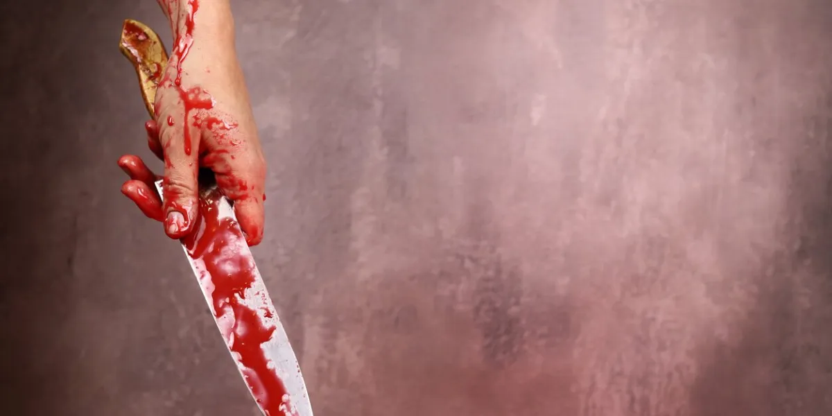 blood woman's hand holding bloody knife on a gray background the concept of violence, murder