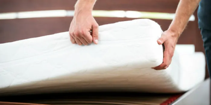 gros plan photo de jeune homme démontrant la qualité du matelas