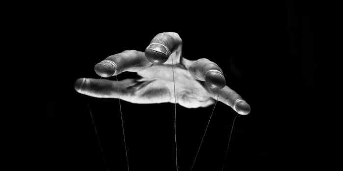 we are being manipulated concept large scary hands with puppet string tied around fingers