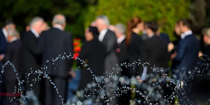 people in blur wearing black suits on funeral