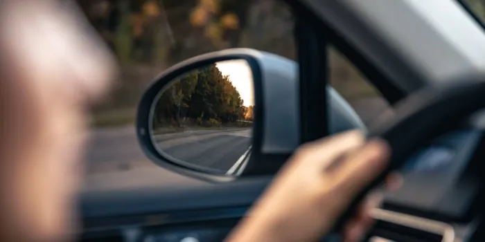 the view of the road in the car's rearview mirror, travel by personal car