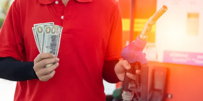 fuel cost saving concept, staff worker hand holding money cash back at gas station