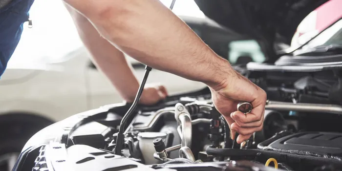 close up hands of unrecognizable mechanic doing car service and maintenance